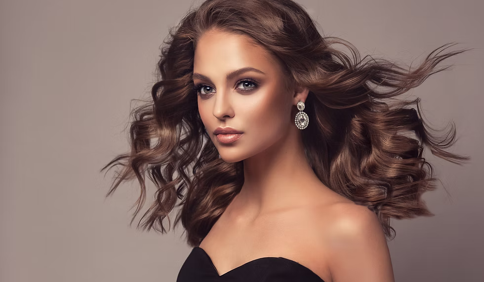 Beautiful model girl with wavy and shiny hair . Brunette woman with curly hairstyle,earrin
